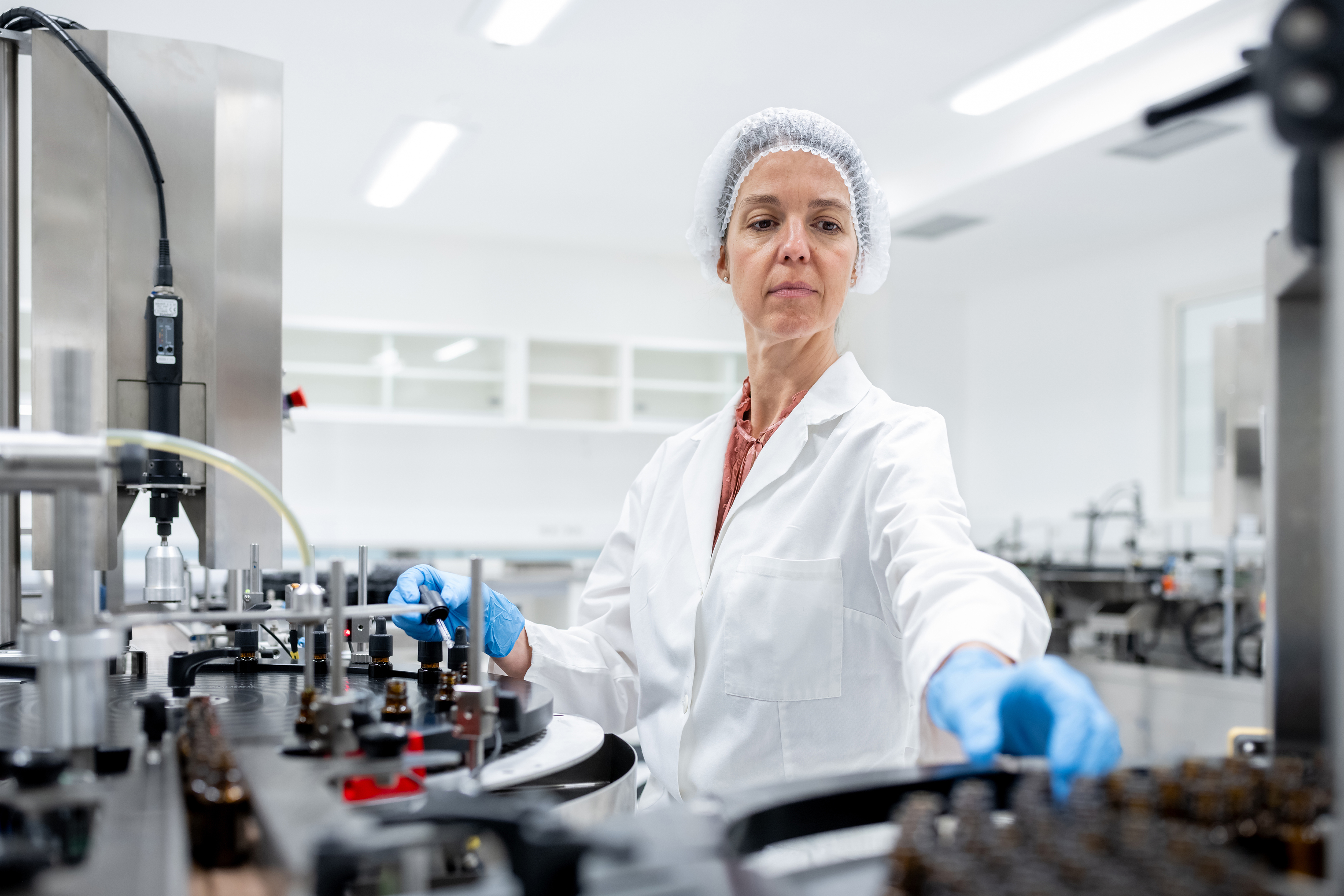 Travailleurs de l&rsquo;industrie pharmaceutique sur une cha&icirc;ne de production pour le remplissage et l&rsquo;emballage de bouteilles.